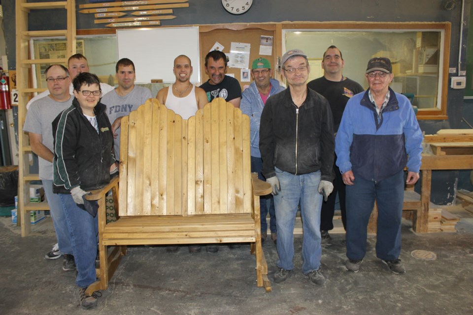 From the left, Estevan Diversified Services participants Mike Tymchuk, Aaron Turner, Candace Mack, Corey Perkowitch, Shane Himmelspach, Mike Samenook, Frank Gorrell, Grant Waldorf, Dawin Styre and Pat Polansky gather around the double rocking chair that they have created for the upcoming United Way Estevan Telethon.