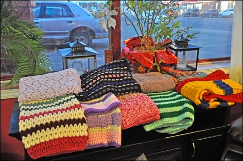 A stack of finished knit and crocheted blankets on display in Crandleberry’s, where the group meets Tuesdays at 7 p.m. to crotchet, knit, chat and drink coffee. Photos by Shannon Kovalsky