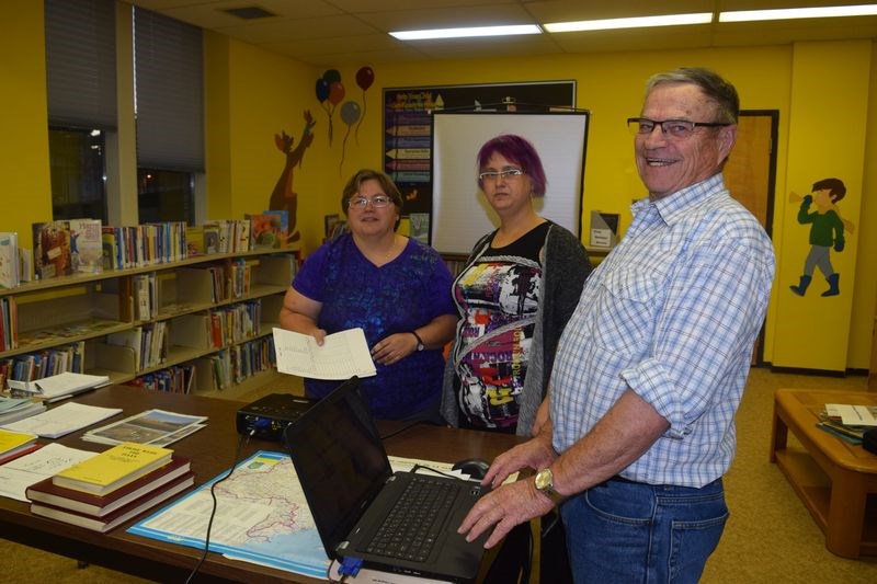 On the invitation of Nicole Larson, centre, the Kamsack librarian, Cindy Koreluik, left, of Kamsack and former Kamsack resident Gerald Moriarty of Yorkton, who are members of the Yorkton Genealogical Society, explained how the Society functions as a resource to persons wishing to delve into their family histories.