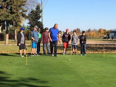 Terry Dennis, centre, taught youths who attended the Big N’ Little golf tournament how to putt at a clinic during the morning of the event.