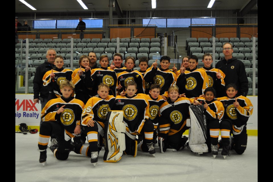 The Estevan Westmoreland Coal peewee AA Bruins celebrate their home tournament championship win over the Regina Tigers at Affinity Place on Sunday.