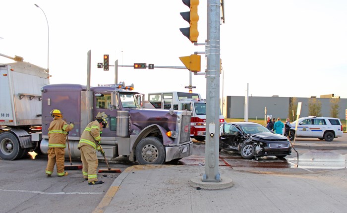 Unfair fight Firefighters clean up following a collision between a tractor-trailer and a car Monday afternoon in the intersection at Hamilton Road and Hwy 9. No one was seriously injured in the crash and, as of press time, there had been no word whether any charges were laid. Traffic had to be rerouted temporarily while police investigated.