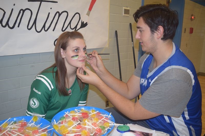 Painting their faces as they got into their sports costumes for the annual Kamsack Comprehensive Institute Fun Night on October 27 were Mikayla Woloshyn and Brayden Fatteicher.