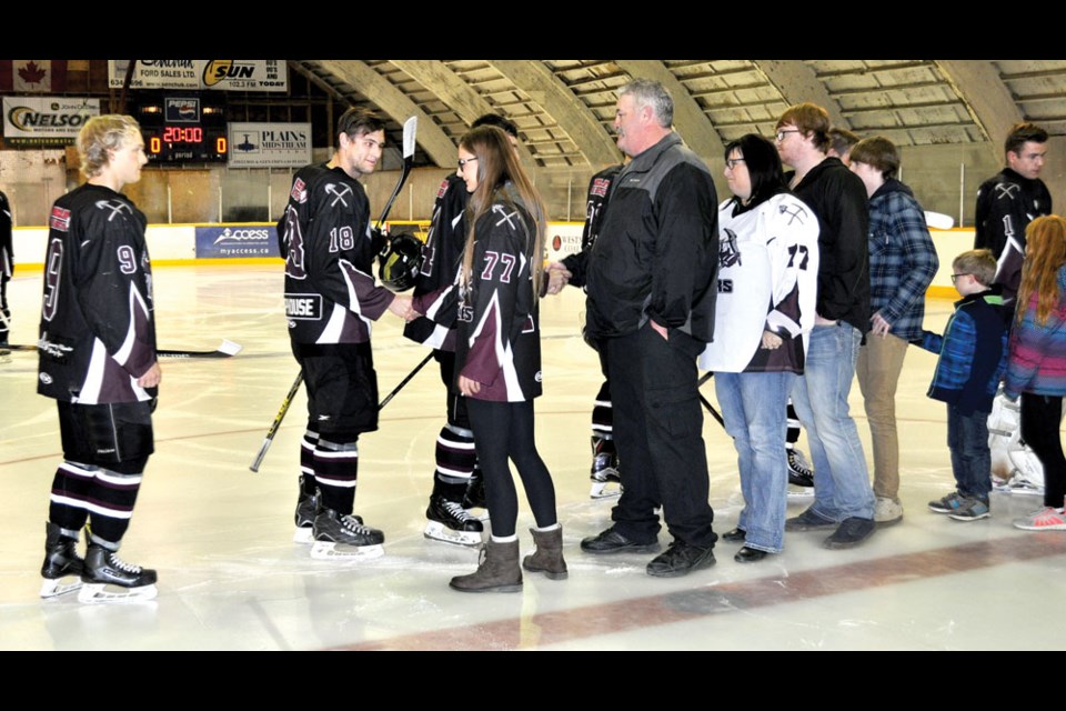 Bienfait Coalers players shake hands with members of Dustin Pratt's family after a the team held a memorial ceremony for the longtime Coaler who passed away this summer. Photo by Jamie Harkins.
