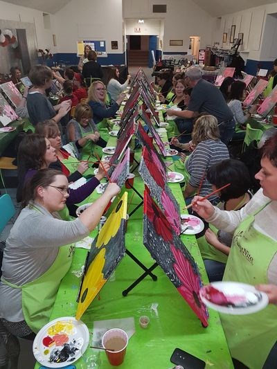 The 55 attendants of the Paint the Town Red Paint Night were hard at work creating their own unique spin on the example painting they used as a reference.