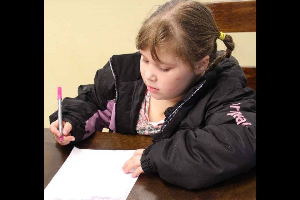 Letters to Santa Kids had the chance to make their requests for Santa at the Yorkton Public Library. Part of the Santa Claus Day celebration, the writing was followed by a showing of the Muppet Christmas Carol. Nakora MacRae, pictured, didn’t forget her puppy in her list of requests.