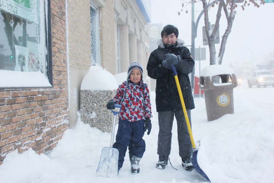Local residents have been busy clearing sidewalks since the storm, including Jello Pagsibigan, left, and his brother John Paul. They shovelled the sidewalk in the 1200-block of Fourth Street on Dec. 5.