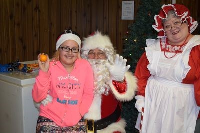 Zennia Lukey, who assisted with maintaining the Canora 4-H Club’s baked goods table, was quick to take a break and have a visit with Santa and Mrs. Claus.