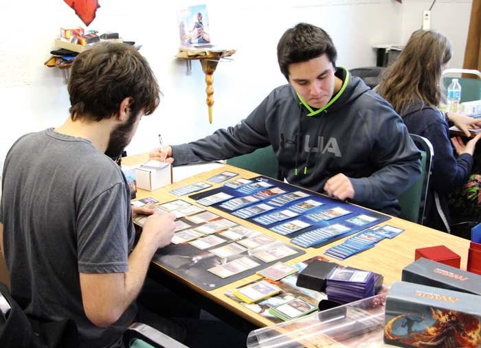 Brandon Smith and Austin Jennings-Plante build their decks in preparation for a Magic: The Gathering tournament at Delver’s Cage. The business has a goal of being an open and welcome place for people to game, whether that means teaching newcomers the ins and outs of games they haven’t played, or putting on tournaments for fans of the various games in the store.