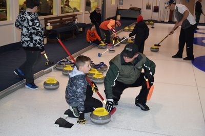 Jayden Norberg, left, took tips from Bob Kolodziejski during kids curling on January 11, which has 24 children registered to learn to curl and is still accepting registrations.