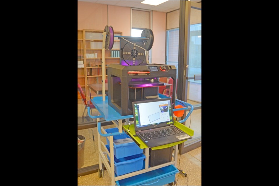 The MakerBot Replicator 3D printer has been unveiled at Lakeland Library Region Headquarters. By heating spools of plastic thread, the impressive piece of equipment can create small, detailed objects in minutes. Right, the printer begins work on a plastic chain. Photos by Shannon Kovalsky