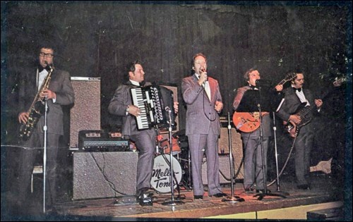The Mellotones: Garnet Speer (saxophone, clarinet), Leon Charabin (accordion), Ken Magnuson (vocals), Russ Iwanchuk (guitar) and Dennis Pidwerbesky (electric bass guitar). The image is scanned from the cover of the Mellotones 1974 album Dancing With the Mello-Tones. The 13-track album features tunes such as South of the Border, Lichtensteiner Polka, Green Green Grass of Home and Leroy Brown.