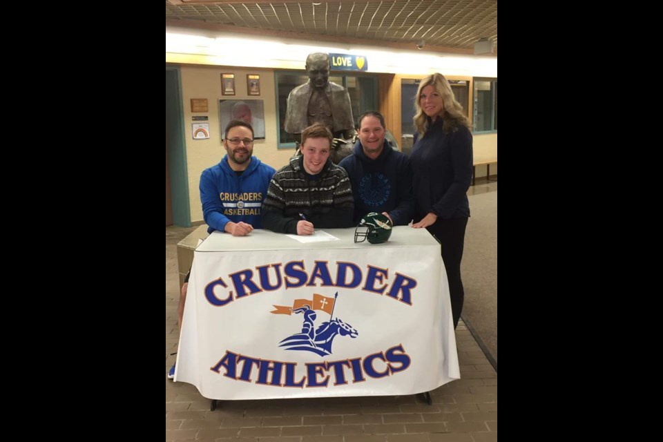Jacob Synsky was joined by John Paul II Crusaders football coach Bruce Yockey and his parents Vic and Roxanne when he signed his letter of intent to join the Presentation College Saints this fall. Photo Submitted.