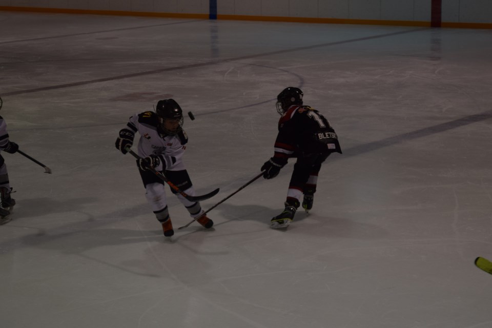 The puck flew when Ty Sleeva, left, and Rylan Bletsky clashed in a game between Canora Atom Cobras Black and Canora Atom Cobras Red.