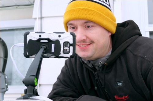 Trevor Altman checks on a cellphone he set up to record the time-lapsed progress of the igloos.