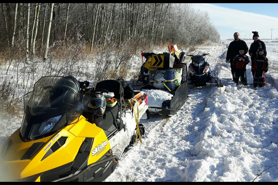 Members of the Preeceville Snowmobile Club have been keeping busy with putting up signs on the snowmobile trail. At work last week, from left, were: Rob, Scott, Carter and Wyatt Scheller.