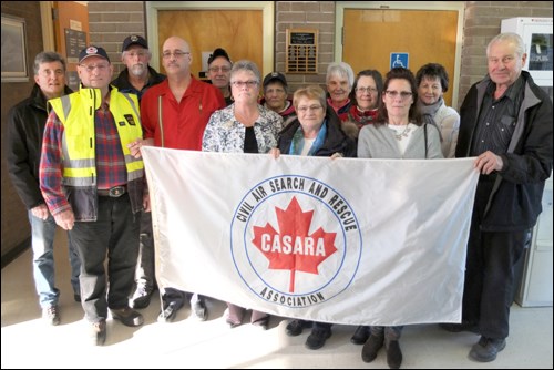 CASARA officials and loved ones of late members pose with the new airport plaque.