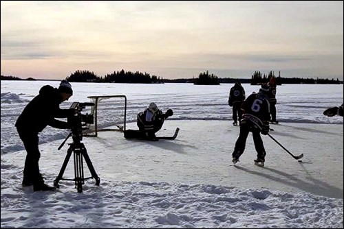 A camera documents Bombers playing hockey on a frozen lake outside Flin Flon.