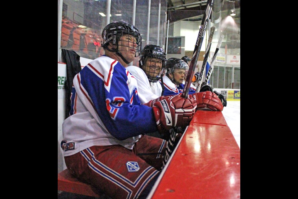 Jim Morton, left, Dennis Kriger and Peter McMullen wait for a shift change during Grinders over-60 hockey Wednesday, February 15 at Gallagher Centre.