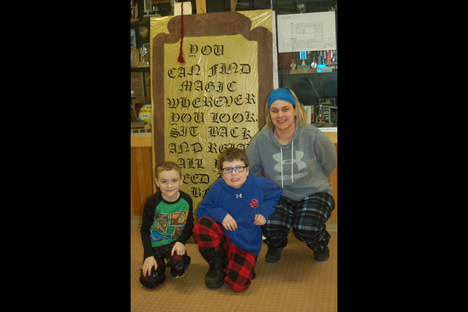 Students and parents were encouraged to have their pictures taken in front of a gigantic book during World Read Aloud Day. From left, were: Blake Descalchuk, Carsyn Galiz and Kyla Galiz.