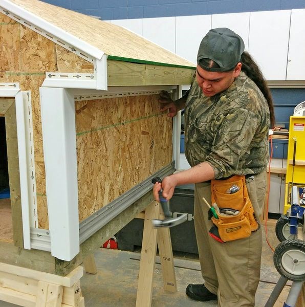 Thunder Strongquill was photographed as he hammered in some nails on a doghouse that was constructed during a housing maintenance/essential skills program at Keeseekoose First Nation.