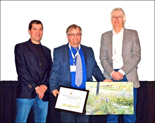 Brian Nattress (centre) receiving the Saskatchewan Prairie Conservation Action Plan Native Prairie Stewardship Award on behalf of the Manitou Cattle Breeders Co-op Pasture. John Hauer (left) and David Shortt (right) with the Sasatchewan Ministry of Agriculture who nominated the group. Photos submitted