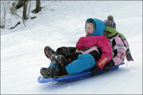 Deven Stener and Cheylynn Stevens slide down the hill at Kin Park on the afternoon of Saturday, Feb. 25. The Flin Flon Kinsmen Club held a sliding day to celebrate World Day of Kindness. - PHOTO BY ERIC WESTHAVER