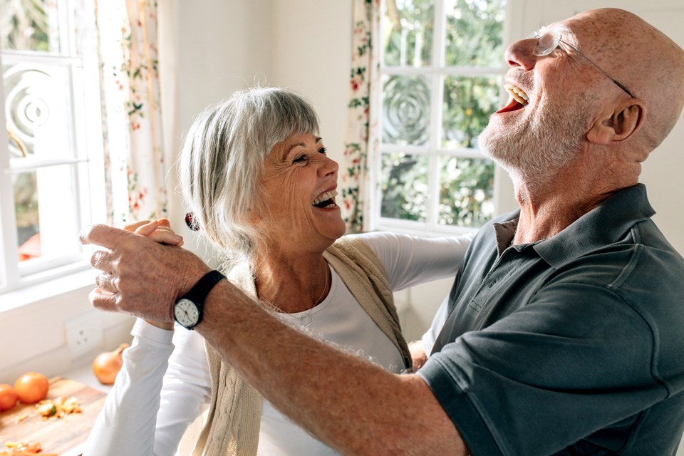 A happy senior couple having fun doing a ballroom dance at home and staying fit.