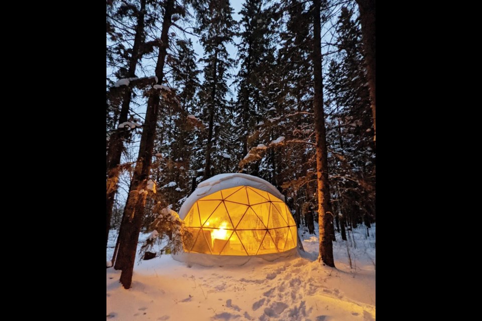 The exterior of a glamping geodome in the forest, surrounded by pillowy snow, at Glamp Good in Alberta. / Glamp Good | Facebook