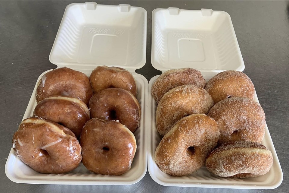 Two open to-go boxes filled with six donuts each, one with sugar coating and the other glazed. / Tina's Cafe & Bakery | Facebook