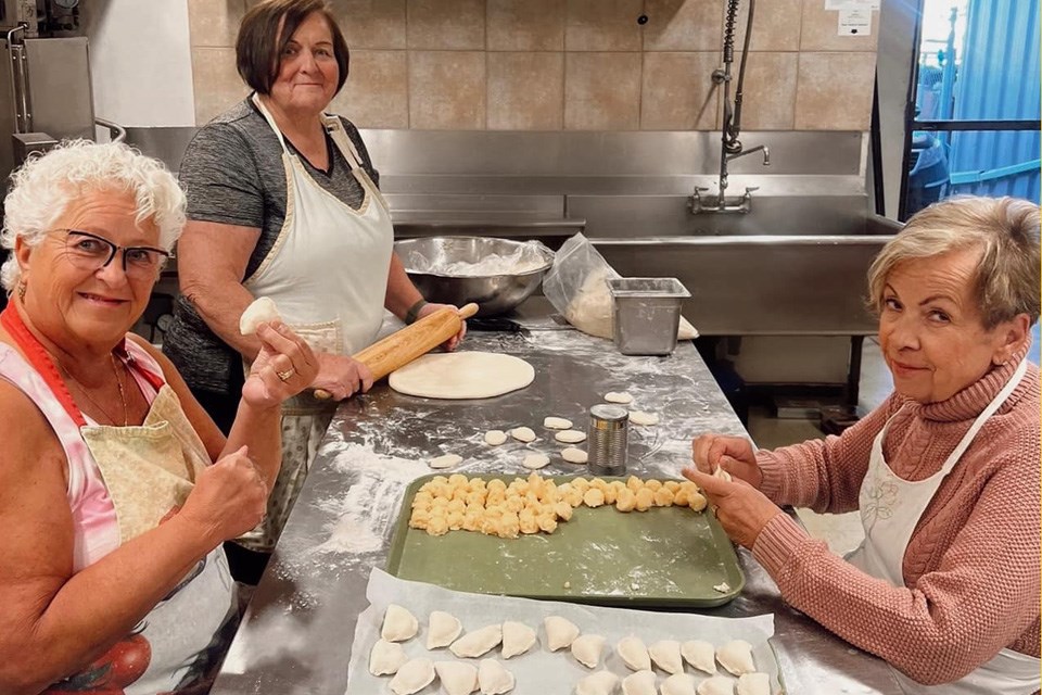 Three women hand-pinching fresh perogies at Saskitoba in Nisku, Alberta / Saskitoba, Facebook