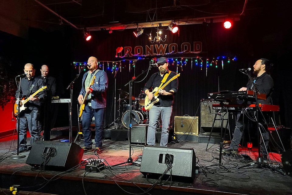 Five musicians play on stage at the Ironwood Stage & Grill with lights all around them. / Ironwood Stage & Grill | Facebook