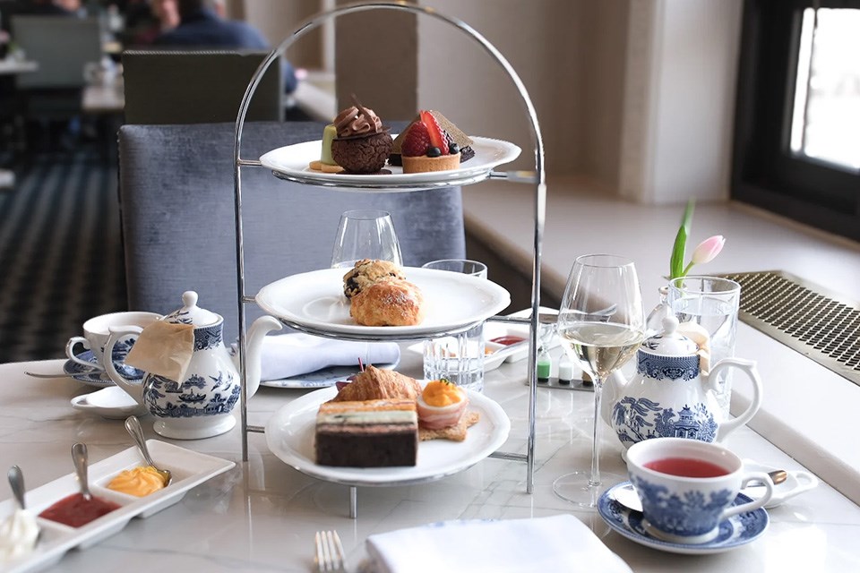 A three-tier dessert display with lovely little pastries next to a teapot at the iconic Fairmont in Alberta. / Fairmont Hotels