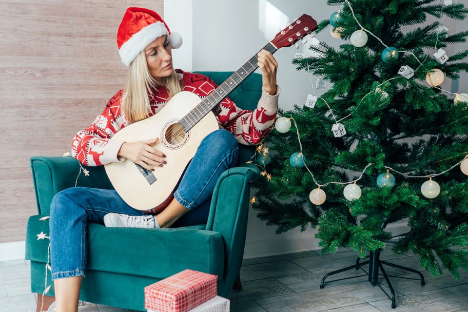 b-woman-with-christmas-hat-playing-guitar-2022-11-15-09-13-04-utc