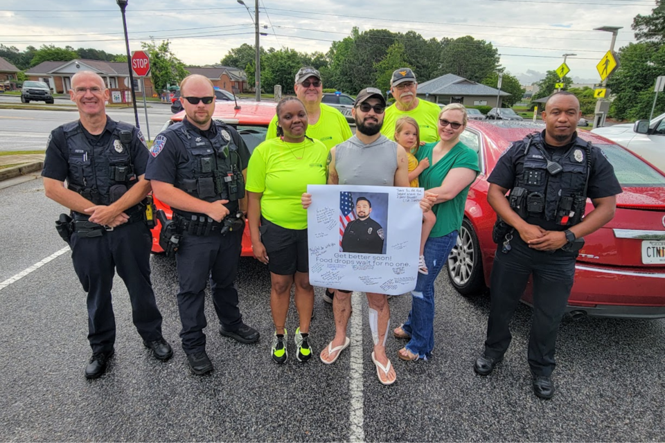 Officer Deloach in center with wife Britany and daughter with fellow SPD officers and FTB volunteers