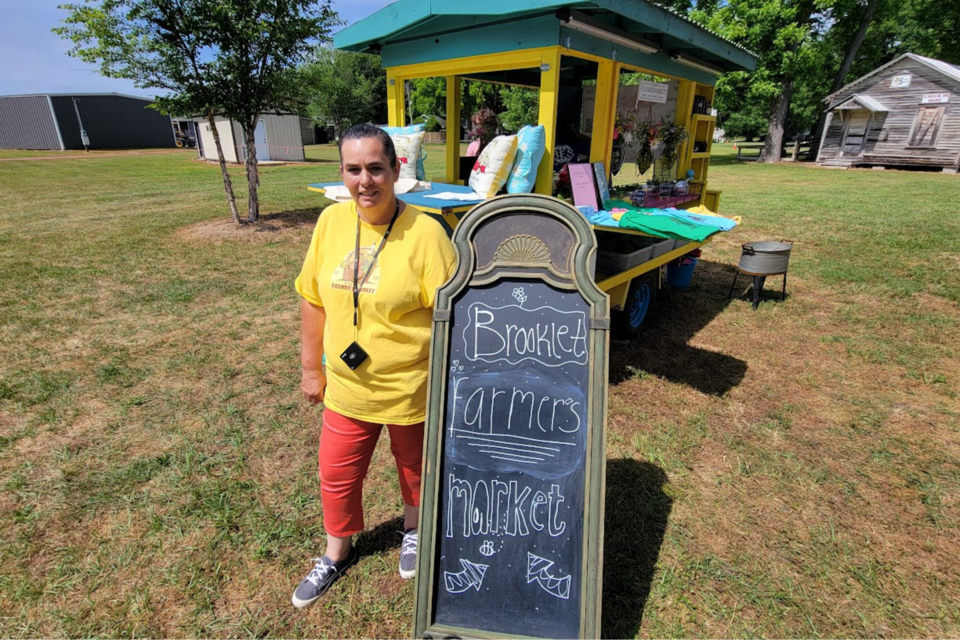 Michele Wilson, coordinator of the Brooklet Farmers Market stands in front of her flower and gift wagon at the market
