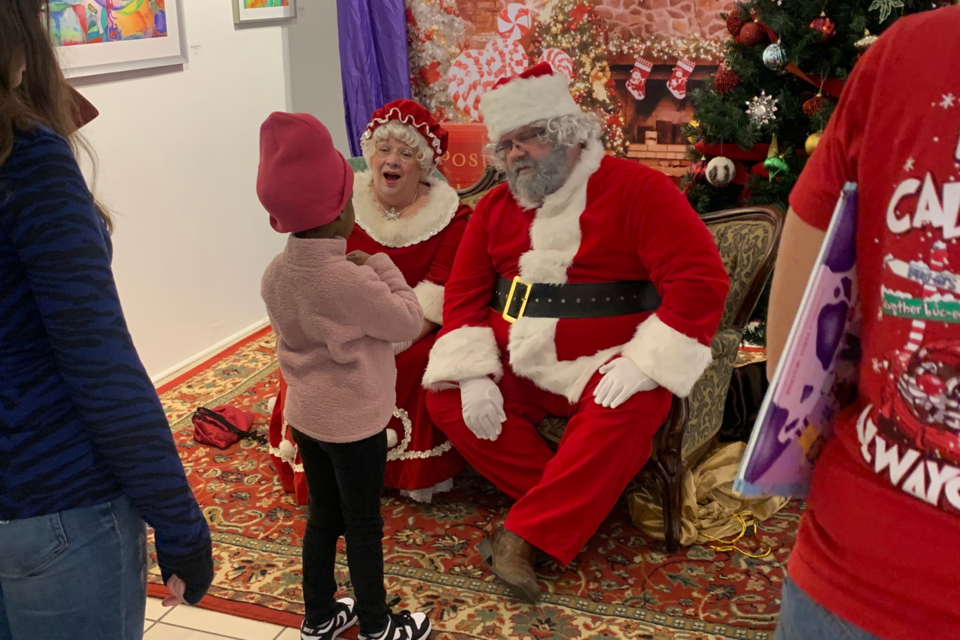 Children take photos and share Christmas wishes with Santa Claus and Mrs. Claus.