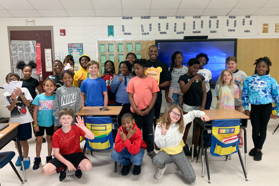 Grice Connect's Brandon Robinson reads "National Regular Average Ordinary Day" to Mrs. Reddick's 4th Grade Class.