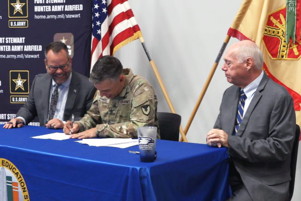 (L-R) Dr. Kyle Marrero, president of Georgia Southern University, and Col. Manuel F. Ramirez, garrison commander at Fort Stewart and Hunter Army Airfield, sign the agreement in front of officials from both organizations at Fort Stewart’s SFC Paul R. Smith Army Education Center. Carl Reiber, Ph.D., Provost and Executive Vice President for Academic Affairs is seated on the right at the table