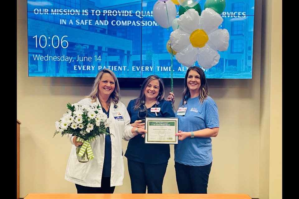 Kathie with her leadership team and colleagues on the fourth floor of EGRMC. 