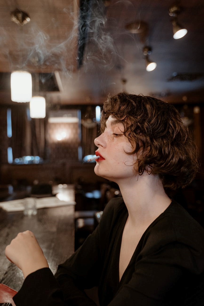 side profile of woman smoking a cigarette