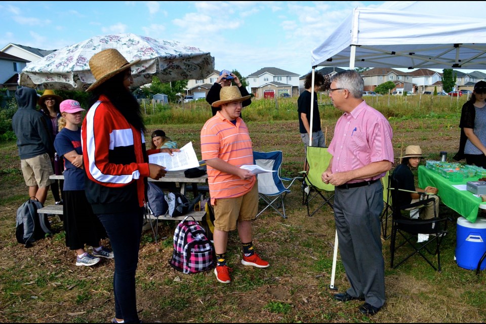 Student farmers Danayt Hibtzghi and Logan Borthwick welcome Guelph MP Lloyd Longfield to the Urban Farm Tour in Castelbury Park. Troy Bridgeman for GuelphToday.com