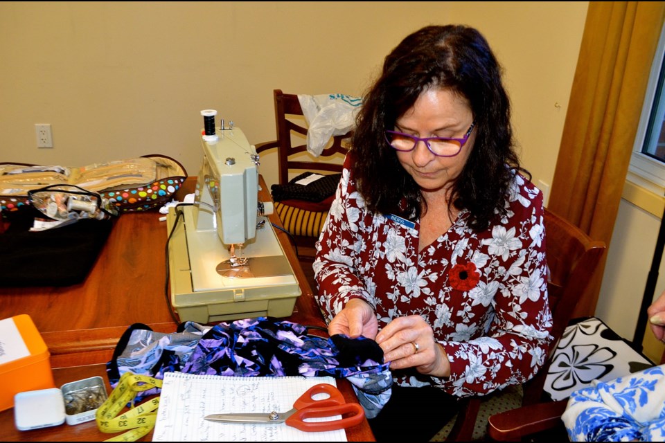 Beryl Holtam of Sew On The Go inspects a stitch while repairing clothes for seniors at the Chartwell Royal on Gordon Retirement Residence. Troy Bridgeman for GuelphToday.com