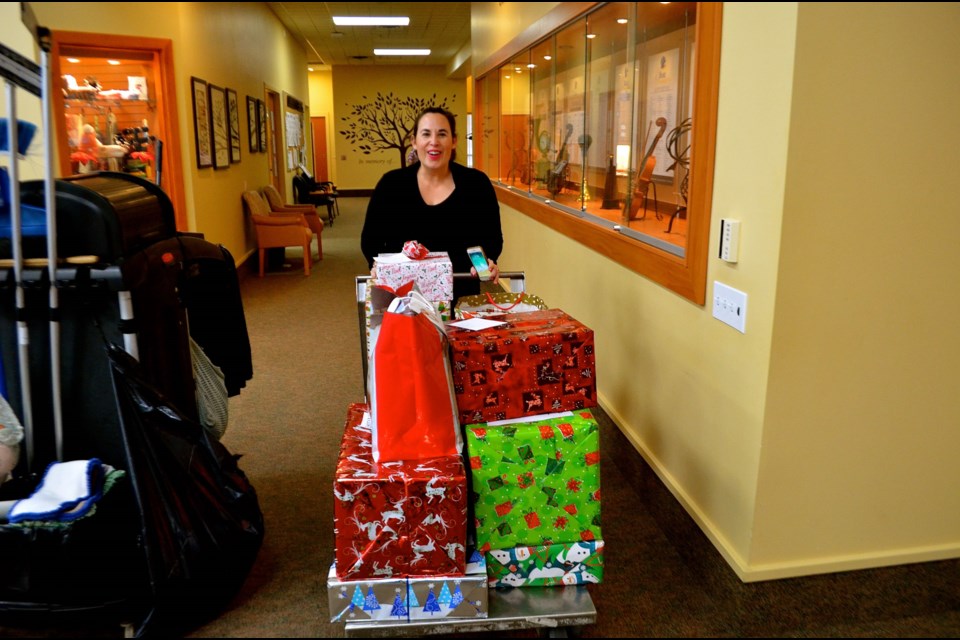 Kyla Rowntree moves wrapped gifts for delivery at the Elliott Community. Troy Bridgeman for GuelphToday.com