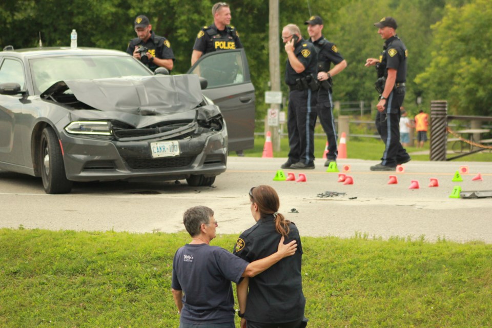 A resident comforts the police officer involved in the crash. Anam Khan/GuelphToday