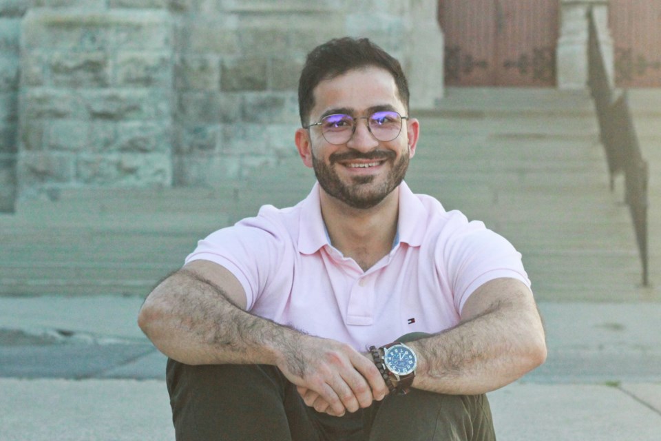 Tamim Holoubi sits in front of the Basilica of Our Lady Immaculate in Guelph. Anam Khan/Guelph