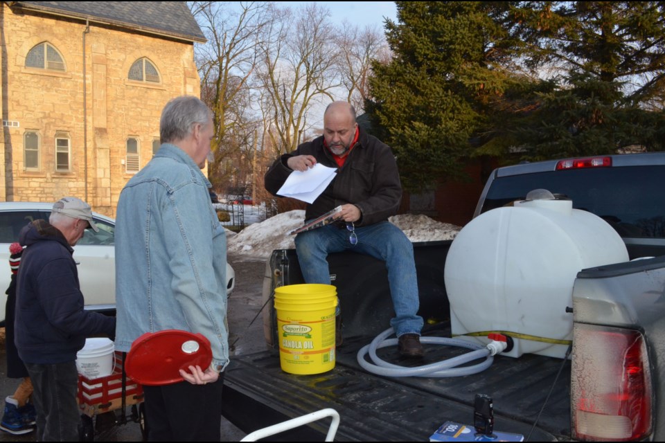 John Dennis collects maple sap from local urban tree tapper Michael McMurray.  Troy Bridgeman/GuelphToday