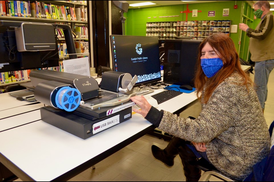 Researcher and labour historian Bonnie Durtnall feeds a reel of microfilm through the microfilm reader at Guelph Public Library.Troy Bridgeman for GuelphToday