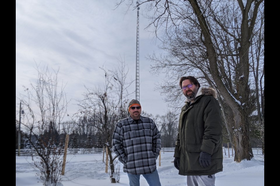 Arnold Stoll (left) and Philip Mullis stand in front of an 80-foot tower built by Mullis on his property in Ariss. Anam Khan/GuelphToday