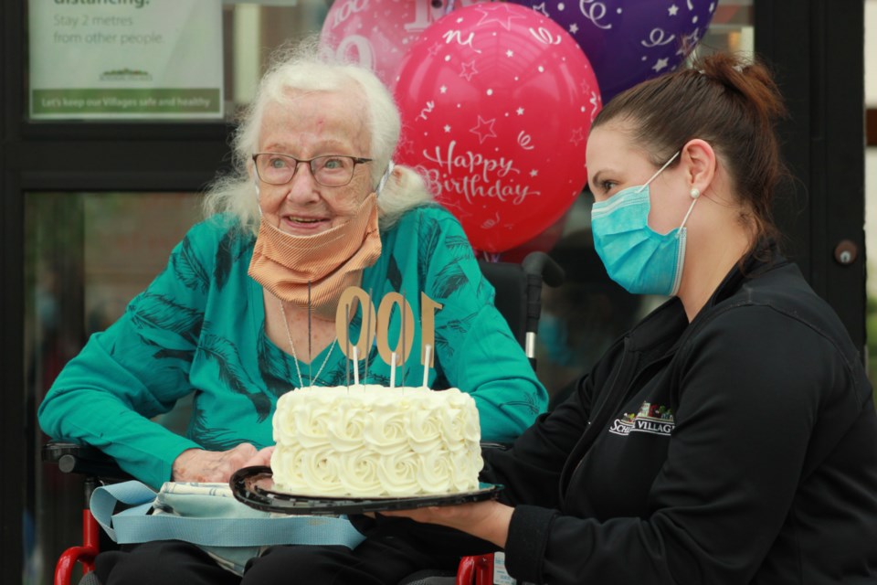 Helen Brimmell is presented with a birthday cake with the number '100' on it by a team member at The Village of Arbour Trails. Anam Khan/GuelphToday